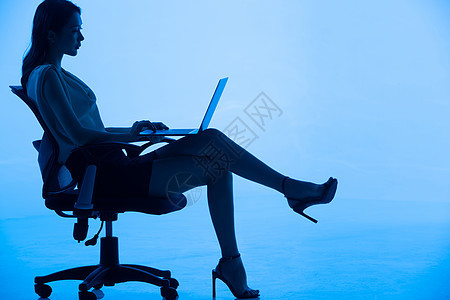 青年女士坐在椅子上使用平板电脑图片