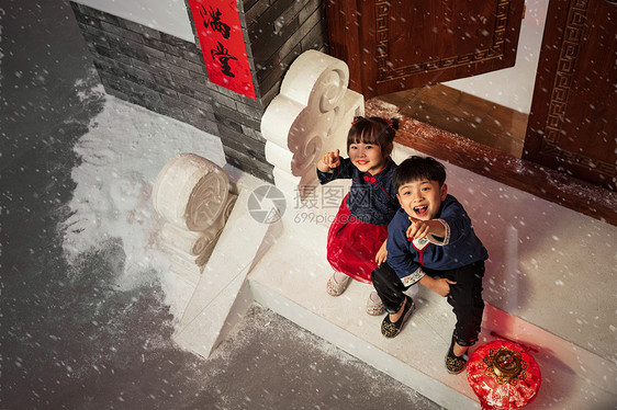 坐在门口台阶上看雪花的男孩女孩图片