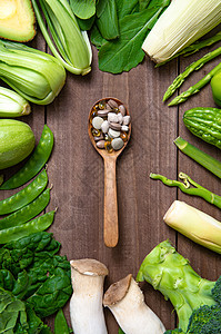 绿色果蔬和木匙上的多色药品高清图片