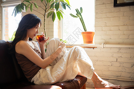 年轻女人在家喝茶休息高清图片