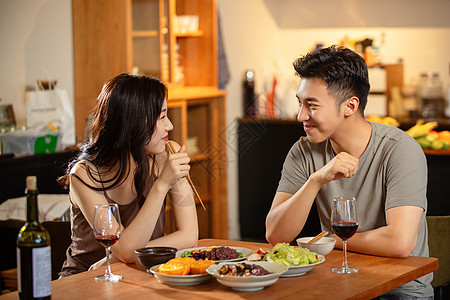 吃蔬菜年轻夫妇在家用餐背景