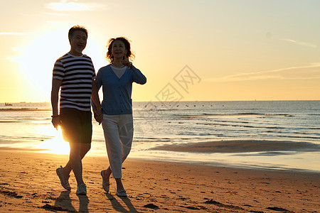 海景夕阳老年夫妇在海边散步背景