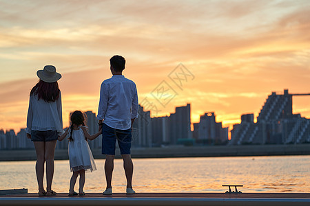 水边建筑一家三口在海边度假背景