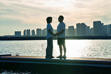 夕阳海景老年夫妇站在在海边背景