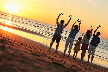 海滩背影在海边度假的快乐家庭背景