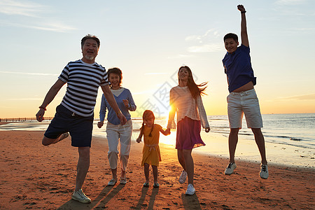 跑步的人剪影在海边度假的快乐家庭背景