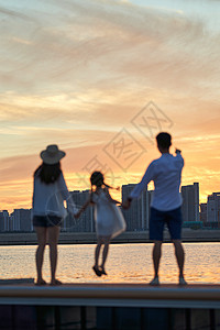 家庭剪影一家三口在海边玩耍背景