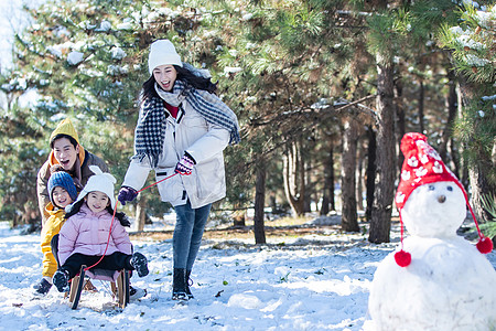 在雪地上玩雪橇的一家人图片