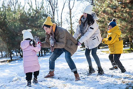 快乐的一家人在雪地里做游戏高清图片