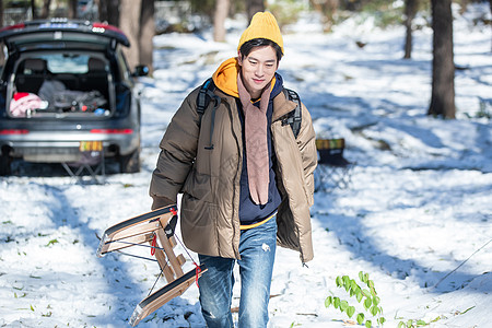 雪地上拿着雪橇的青年男人图片