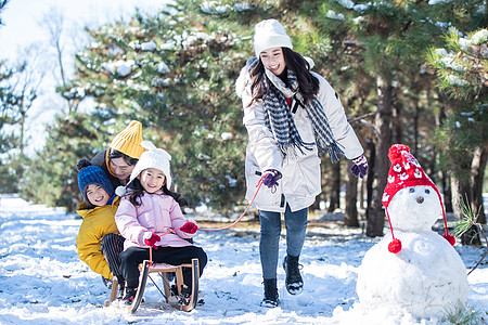 在雪地上玩雪橇的一家人图片