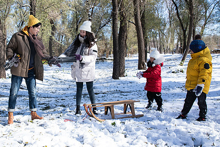 在雪地上准备玩雪橇的一家人图片