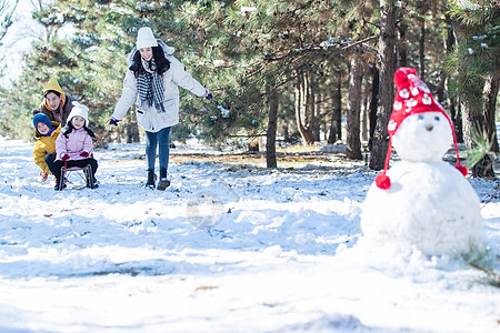 在雪地上玩雪橇的一家人图片