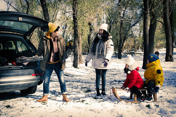 在雪地上准备玩雪橇的一家人图片