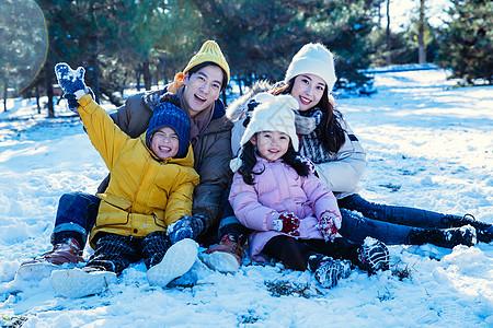 雪地玩耍快乐的一家人坐在雪地上背景
