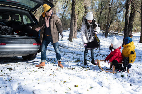 在雪地上准备玩雪橇的一家人图片