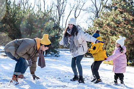 快乐的一家人在雪地里做游戏高清图片