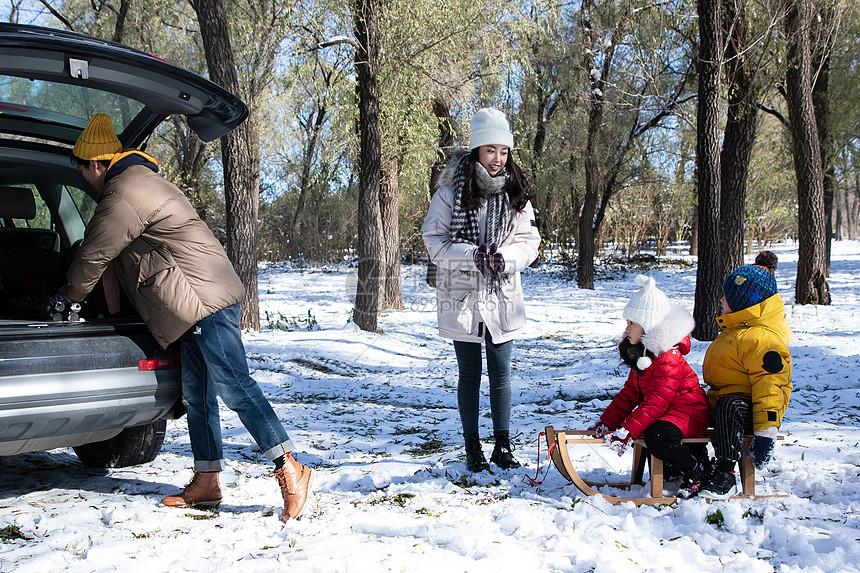 在雪地上准备玩雪橇的一家人图片