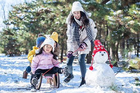 在雪地上玩雪橇的一家人图片