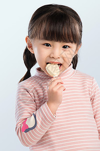 吃零食的小孩可爱的小女孩正在吃零食背景