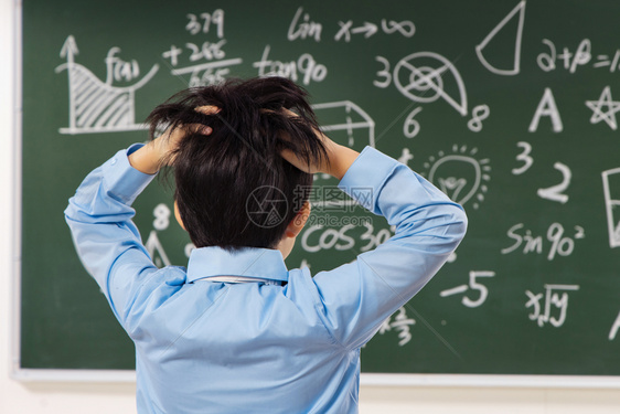 小学男生被数学题难住的背影图片