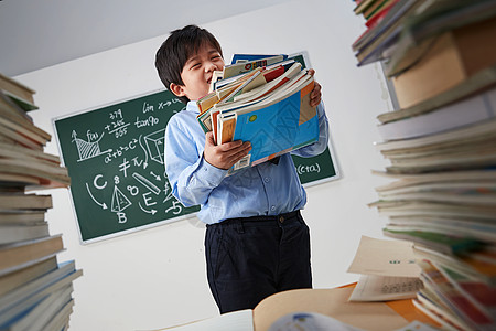 搬着沉重课本的小学男生图片