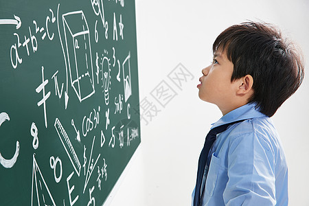 小学男生研究黑板上的数学题图片