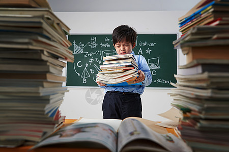 搬着沉重课本的小学男生图片