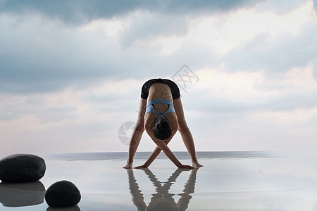 唯美瑜伽年轻女人在水面上练习瑜伽背景