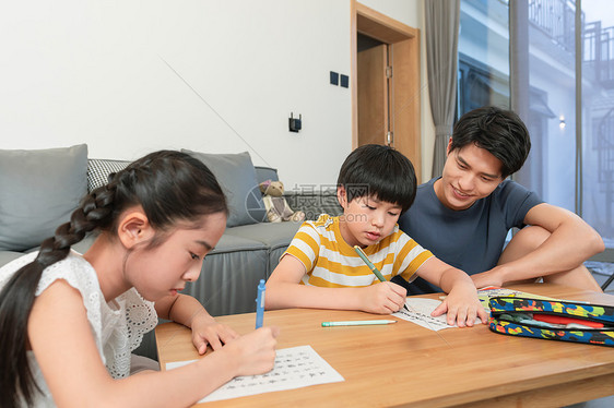 年轻爸爸辅导孩子做作业图片