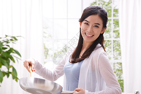 年轻女人在厨房做饭图片