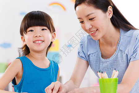 幼儿园里教师在指导女孩学习图片