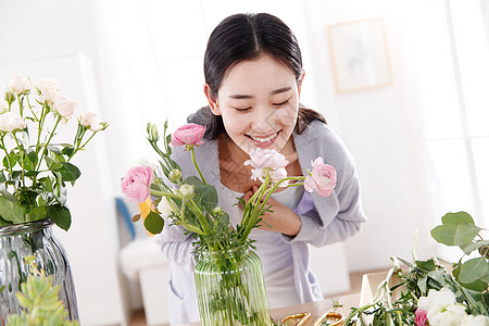 青年女人在闻鲜花的香味图片