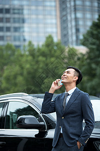 商务男士靠在汽车上打电话图片
