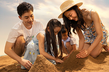 快乐的四口之家在沙滩上玩沙子图片