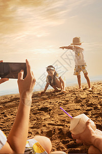 沙滩上青年夫妇为孩子拍照图片