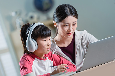 年轻妈妈辅导女儿上网课图片