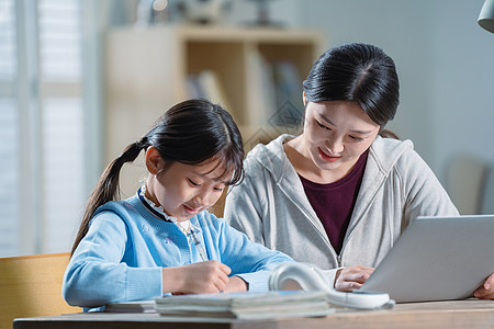 电子作业年轻妈妈辅导女儿学习背景