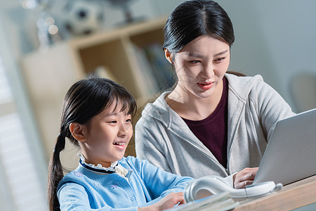 电子作业年轻妈妈辅导女儿学习背景