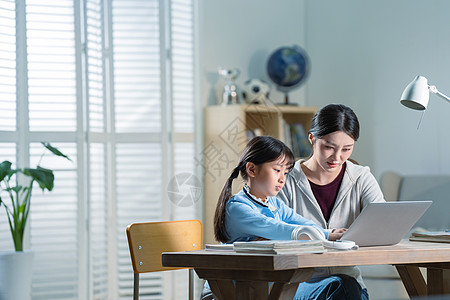 电子作业年轻妈妈辅导女儿学习背景