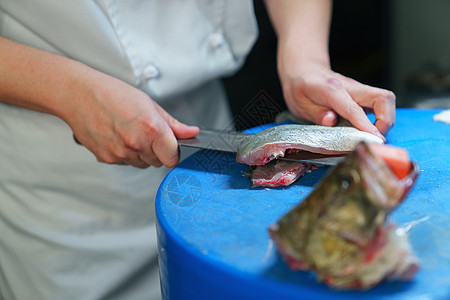 厨师使用菜刀将鱼切菱形刀段图片