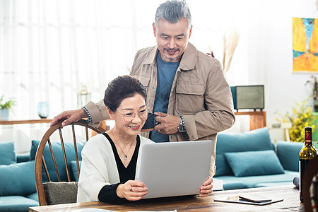 幸福的中老年夫妇在家使用笔记本电脑图片