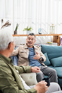 快乐的中老年男士坐在沙发上聊天高清图片