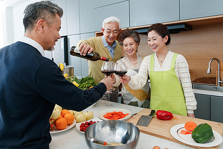 快乐的中老年人在厨房举杯庆祝图片