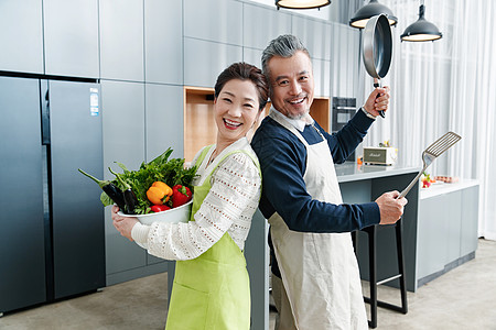 快乐的中老夫妇在厨房做饭图片