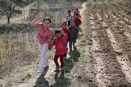 乡村老师和学生走在山路上图片