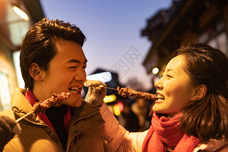 青年夫妇逛街吃羊肉串图片