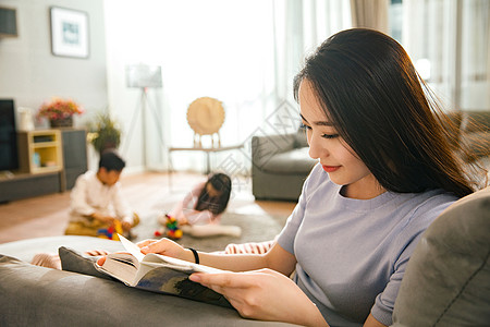 爱读书的女孩母亲和男孩女孩在客厅背景