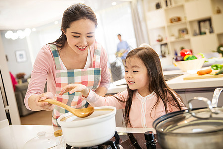 休闲生活年轻妈妈和女儿在厨房背景