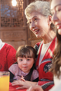 淘宝新年聚惠趴聚会上祖母抱着可爱的孙女背景